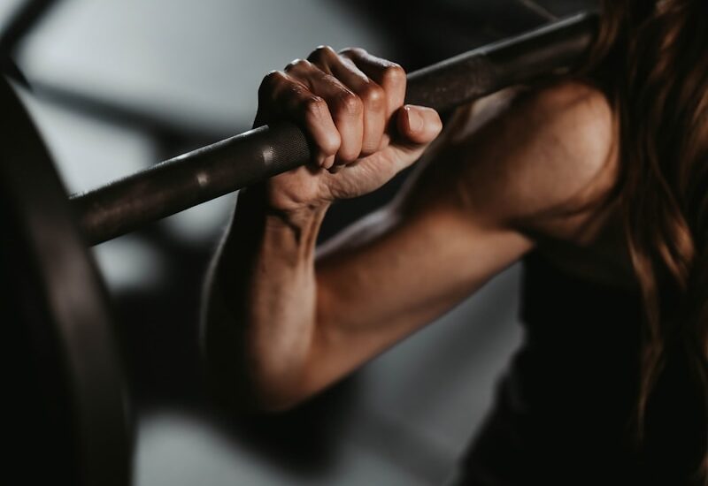 A woman lifting a barbell in a gym